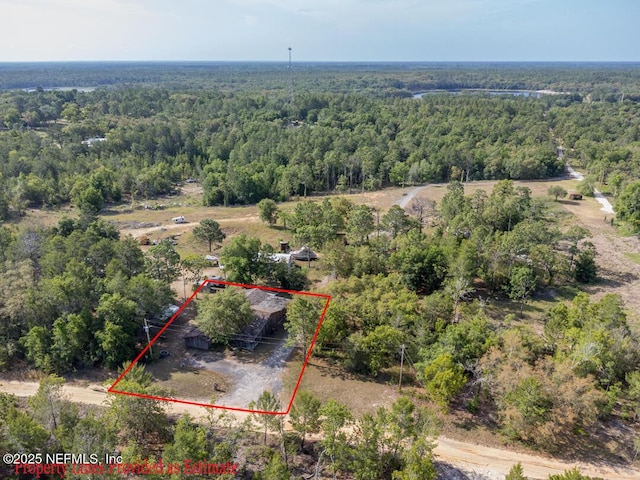 birds eye view of property featuring a wooded view