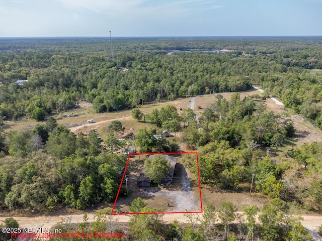 birds eye view of property with a view of trees
