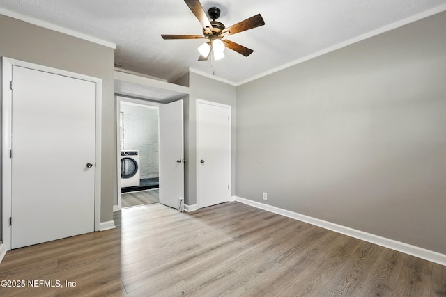 367 Orange Ave, Baldwin, FL 32234 - unfurnished bedroom featuring washer / dryer, baseboards, crown molding, and wood finished floors