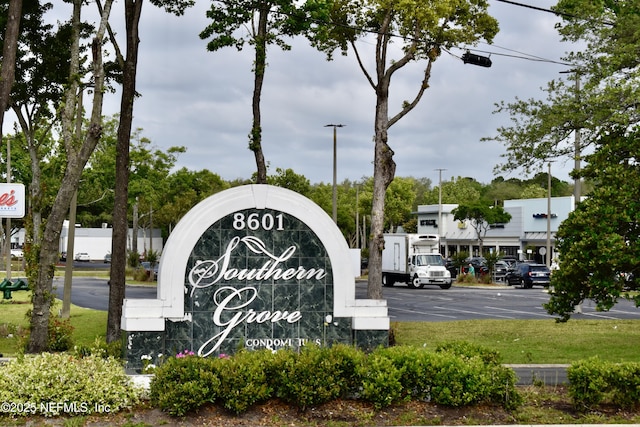 community / neighborhood sign featuring uncovered parking