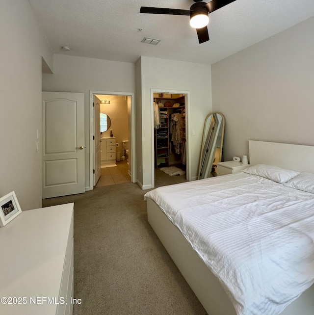 bedroom featuring connected bathroom, visible vents, carpet floors, a spacious closet, and a closet