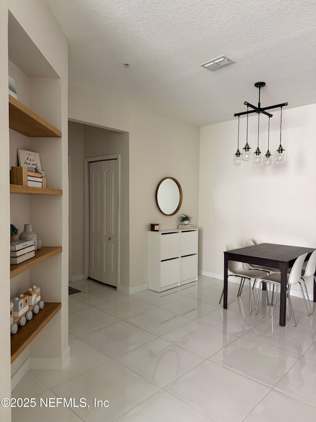 8601 Beach Blvd Unit 711, Jacksonville, FL 32216 - dining room featuring a textured ceiling, baseboards, and light tile patterned flooring