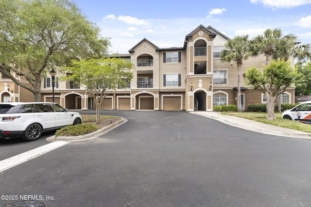 10961 Burnt Mill Rd Unit 318, Jacksonville, FL 32256 - view of front of property featuring a garage, stucco siding, and driveway