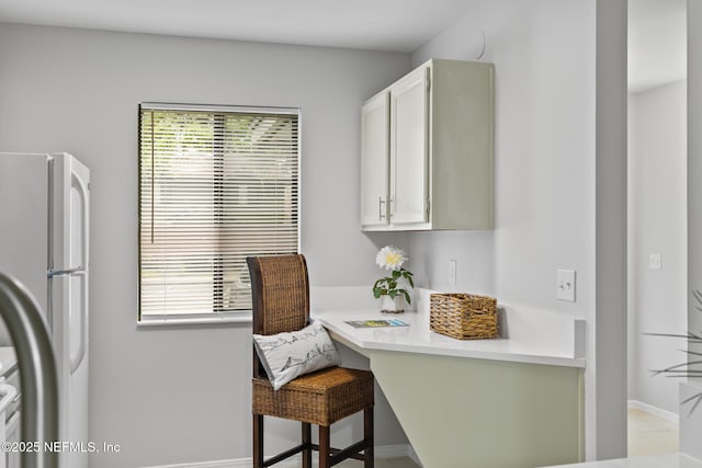 1909 University Blvd S Unit 204, Jacksonville, FL 32216 - interior space featuring freestanding refrigerator, a kitchen breakfast bar, a wealth of natural light, and light countertops