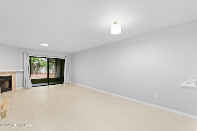 1909 University Blvd S Unit 204, Jacksonville, FL 32216 - unfurnished living room featuring a tile fireplace and baseboards