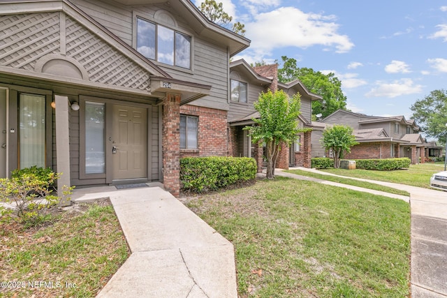 1909 University Blvd S Unit 204, Jacksonville, FL 32216 - doorway to property featuring a yard and brick siding
