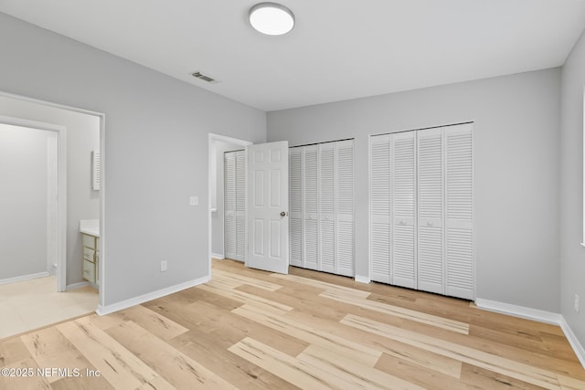 1909 University Blvd S Unit 204, Jacksonville, FL 32216 - unfurnished bedroom featuring baseboards, light wood finished floors, multiple closets, and visible vents