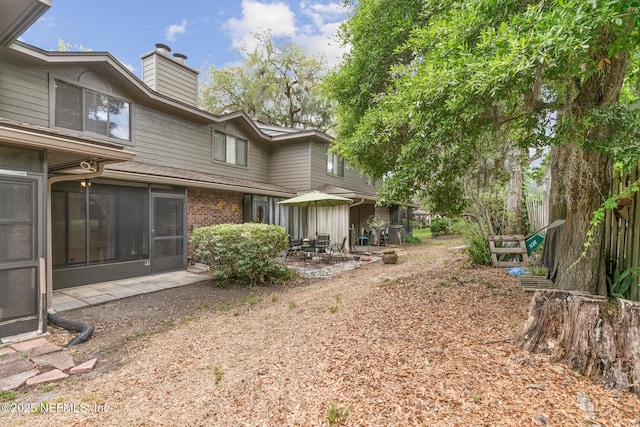 1909 University Blvd S Unit 204, Jacksonville, FL 32216 - back of house featuring brick siding, a patio, and a chimney