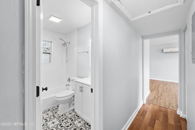 full bathroom featuring vanity, wood finished floors, toilet, an AC wall unit, and shower / bathing tub combination