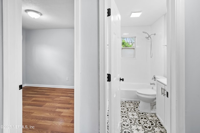 full bathroom with toilet, baseboards, bathing tub / shower combination, and vanity
