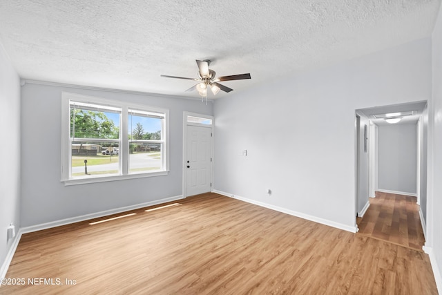 unfurnished room with baseboards, a textured ceiling, and light wood-style flooring