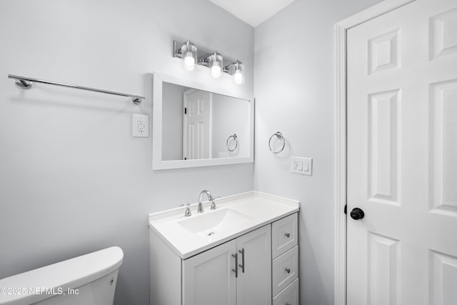 half bath featuring vanity and toilet