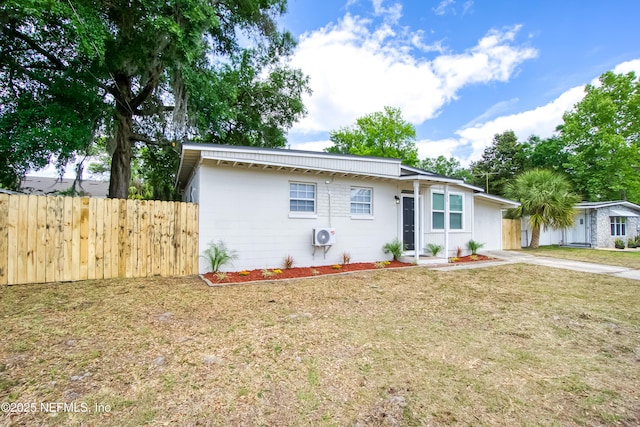 view of front of property featuring fence, driveway, and a front lawn
