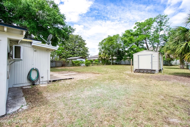 view of yard featuring an outdoor structure, fence, and a storage shed