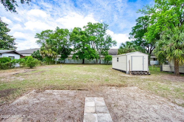 view of yard featuring an outdoor structure, fence, and a shed