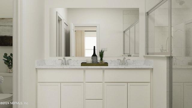 full bathroom featuring a sink, a stall shower, toilet, and double vanity