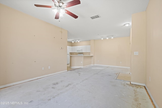 empty room featuring ceiling fan, visible vents, track lighting, and baseboards