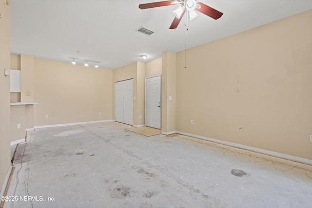 interior space with baseboards, ceiling fan, and visible vents