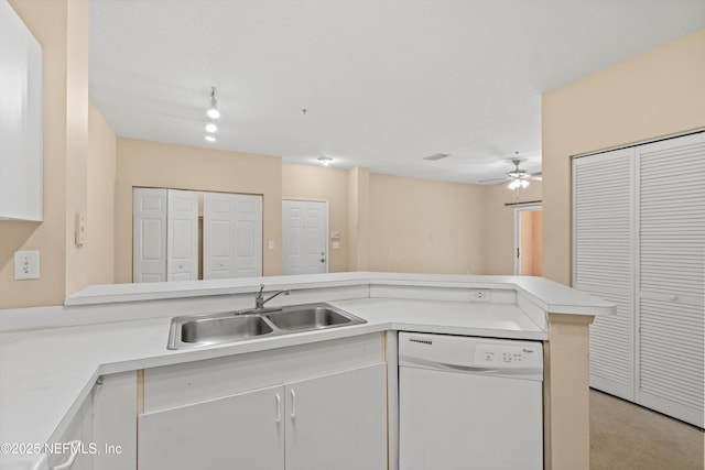 kitchen with a ceiling fan, dishwasher, a sink, light countertops, and a peninsula