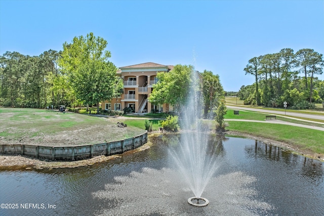view of community with a lawn and a water view