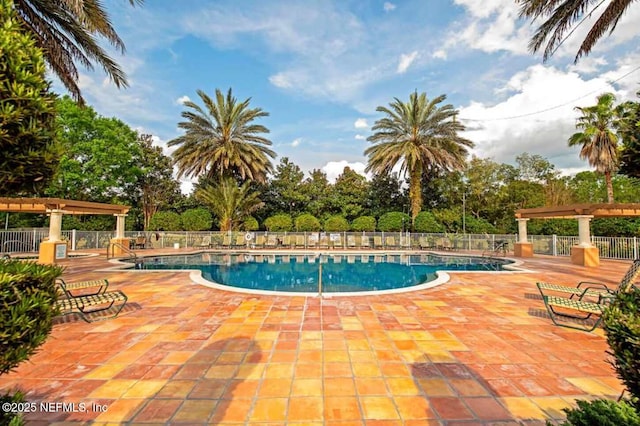 community pool with a patio and fence