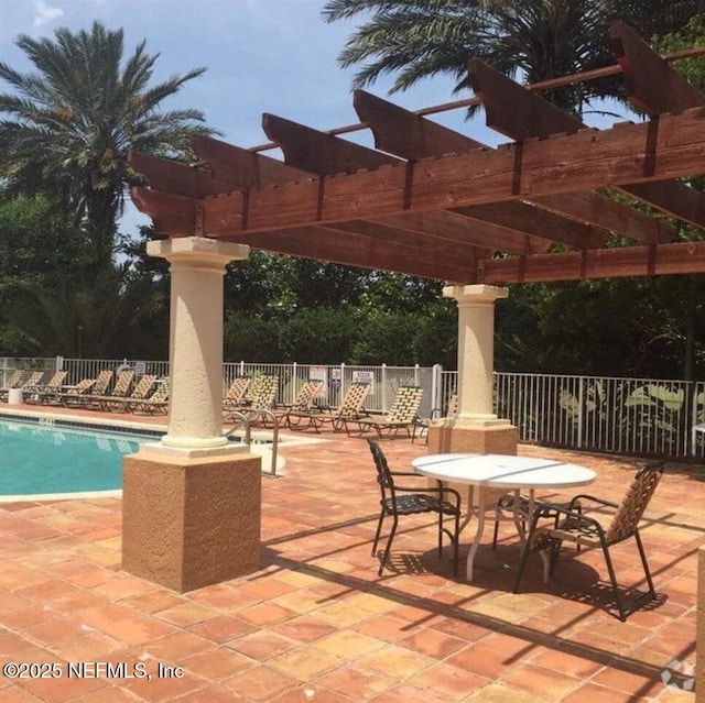 view of patio / terrace featuring a community pool, a pergola, and fence