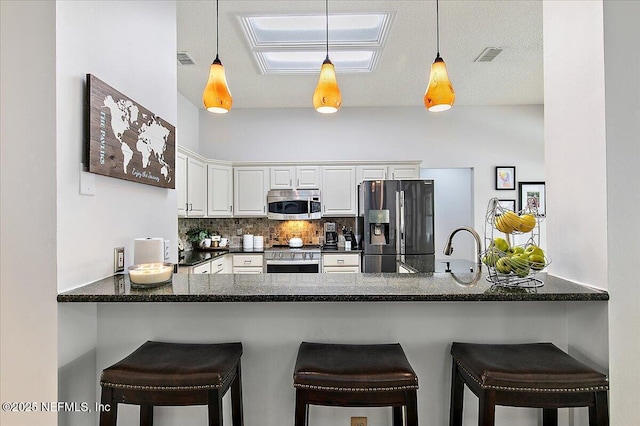 185 Edgewater Branch Dr, Saint Johns, FL 32259 - kitchen featuring backsplash, pendant lighting, white cabinets, a peninsula, and stainless steel appliances