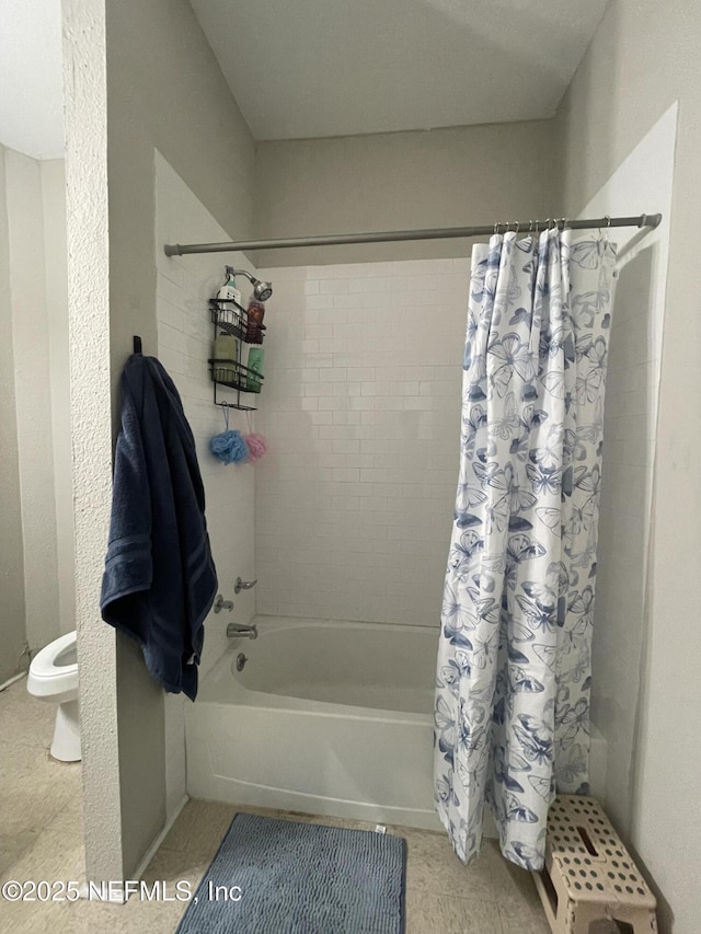 bathroom featuring tile patterned floors, shower / bath combination with curtain, and toilet