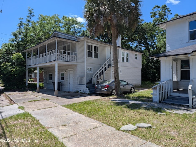 view of front of house featuring stairway and a front yard