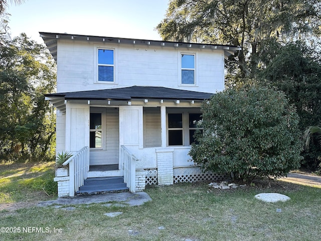 view of front of house featuring covered porch and a front yard