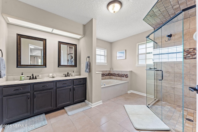 full bath with double vanity, a shower stall, a sink, and a garden tub