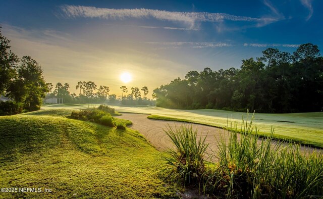view of property's community with a lawn and view of golf course