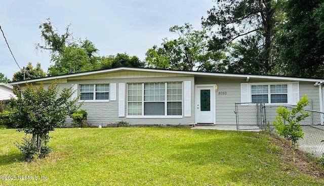 view of front facade with a front lawn and fence