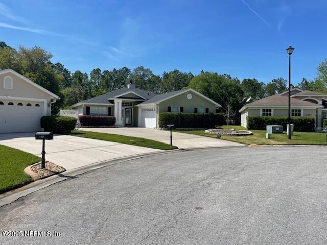 1831 Moss Creek Dr SW, Fleming Island, FL 32003 - single story home with a garage, concrete driveway, and a front lawn