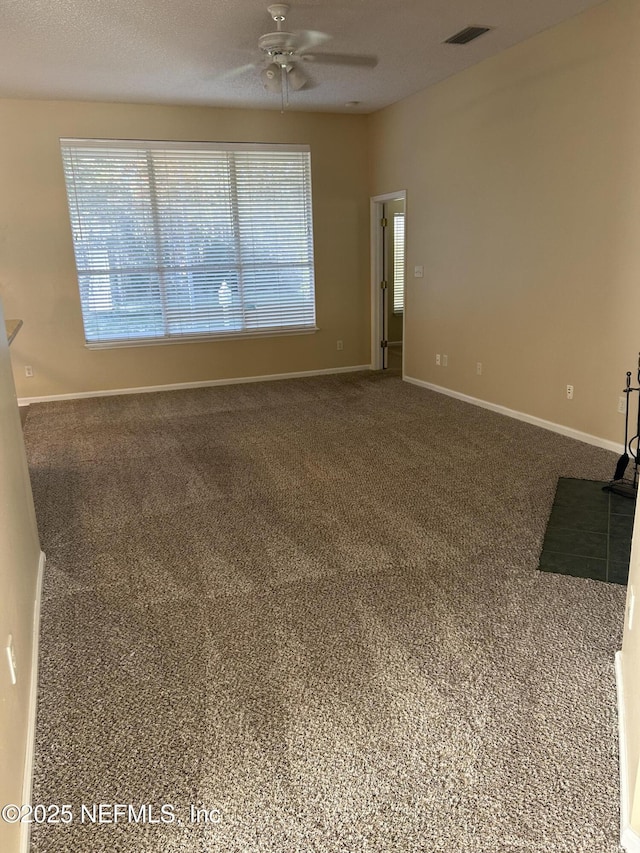 1831 Moss Creek Dr SW, Fleming Island, FL 32003 - unfurnished living room featuring visible vents, a ceiling fan, baseboards, and carpet flooring
