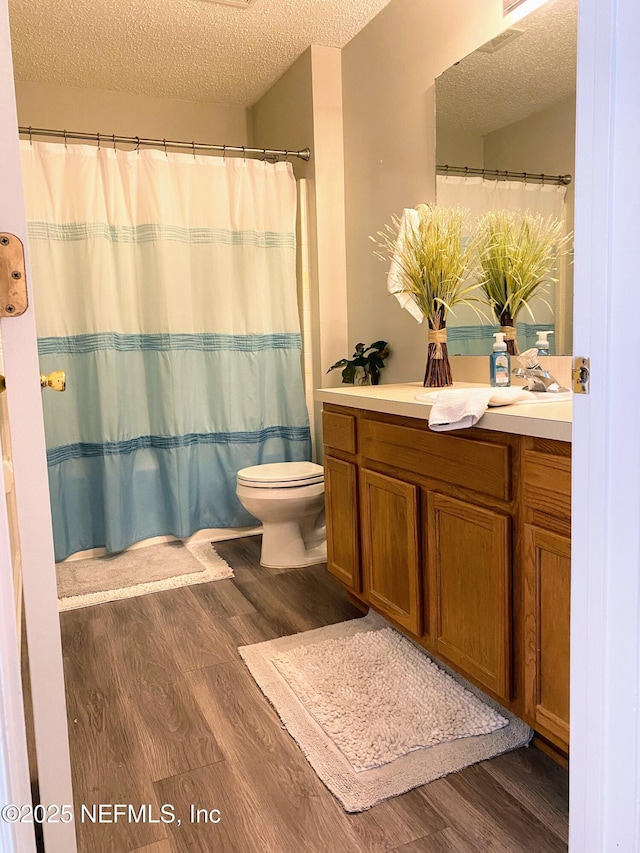 1831 Moss Creek Dr SW, Fleming Island, FL 32003 - bathroom featuring a textured ceiling, wood finished floors, and toilet