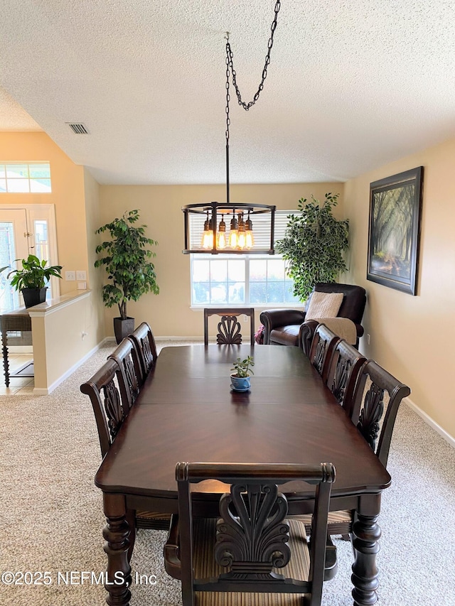 1831 Moss Creek Dr SW, Fleming Island, FL 32003 - carpeted dining area with baseboards, visible vents, a textured ceiling, and a chandelier