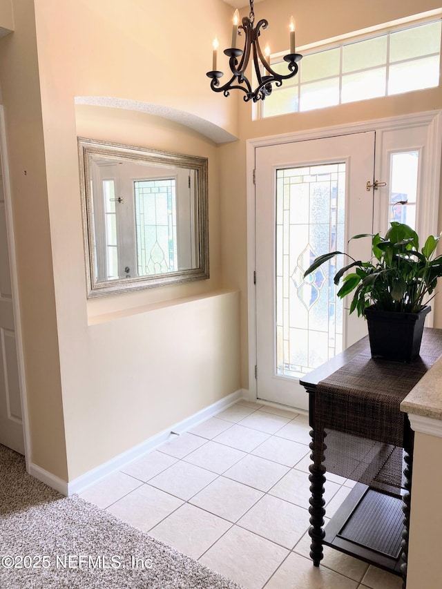 1831 Moss Creek Dr SW, Fleming Island, FL 32003 - foyer featuring plenty of natural light, baseboards, light tile patterned floors, and an inviting chandelier