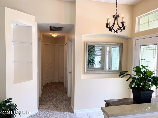 1831 Moss Creek Dr SW, Fleming Island, FL 32003 - interior space featuring a towering ceiling, light colored carpet, visible vents, baseboards, and a chandelier
