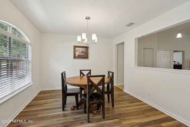 13198 Ebbtide Ct, Jacksonville, FL 32225 - dining room featuring a chandelier, wood finished floors, baseboards, and a textured ceiling