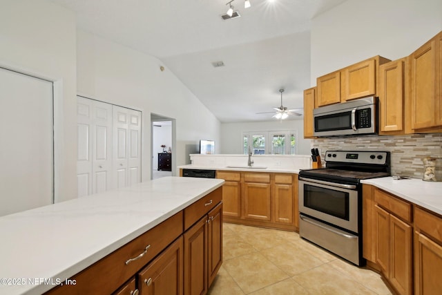 13198 Ebbtide Ct, Jacksonville, FL 32225 - kitchen featuring appliances with stainless steel finishes, a sink, lofted ceiling, decorative backsplash, and a peninsula