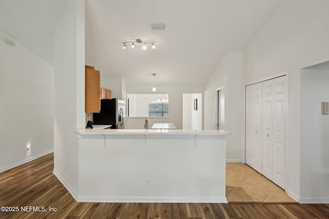13198 Ebbtide Ct, Jacksonville, FL 32225 - kitchen featuring stainless steel refrigerator with ice dispenser, light wood-type flooring, light countertops, a peninsula, and baseboards