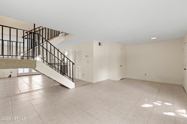 8195 Trafalgar Sq, Jacksonville, FL 32217 - unfurnished living room with stairs, visible vents, and light tile patterned flooring