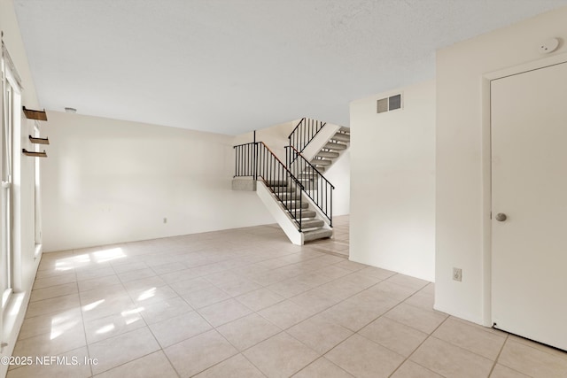 8195 Trafalgar Sq, Jacksonville, FL 32217 - empty room featuring light tile patterned floors, stairway, and visible vents