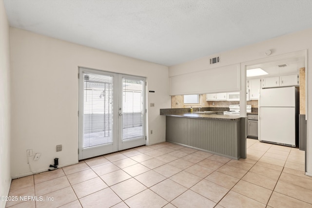 8195 Trafalgar Sq, Jacksonville, FL 32217 - kitchen featuring french doors, white appliances, visible vents, a peninsula, and dark countertops