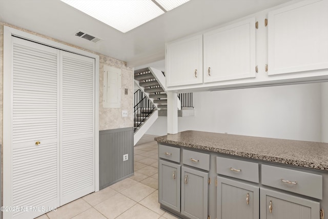 8195 Trafalgar Sq, Jacksonville, FL 32217 - kitchen with light tile patterned floors, visible vents, white cabinets, and gray cabinetry