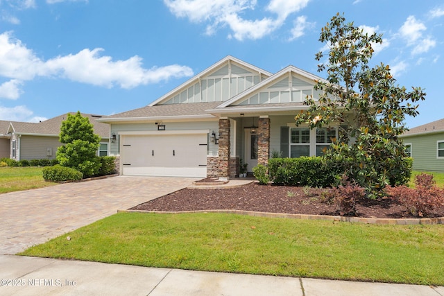 124 Tintamarre Dr, Saint Augustine, FL 32259 - craftsman house featuring an attached garage, a front lawn, stone siding, board and batten siding, and decorative driveway