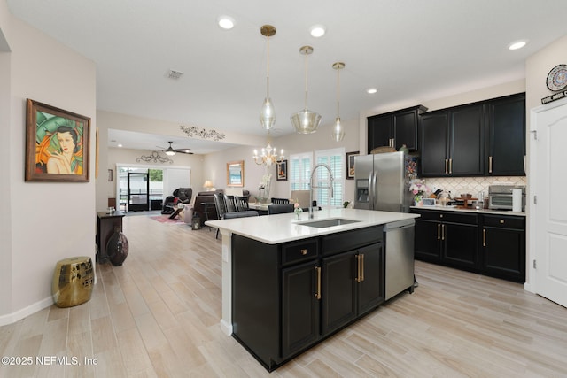 124 Tintamarre Dr, Saint Augustine, FL 32259 - kitchen featuring dark cabinets, appliances with stainless steel finishes, a sink, and light wood finished floors