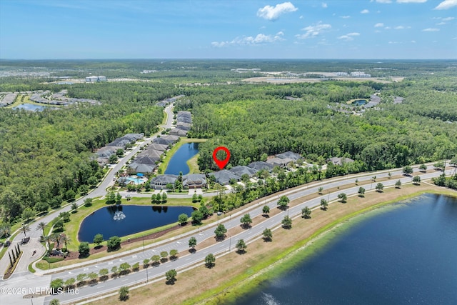 birds eye view of property featuring a wooded view and a water view