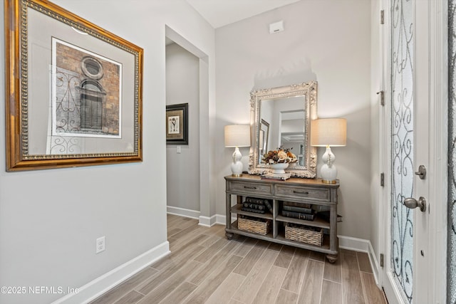 hallway featuring wood finished floors and baseboards
